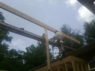 Carpenter setting a ridge beam over a new addition frame — Ice Dam Removal by Roofing Brothers in East Bend