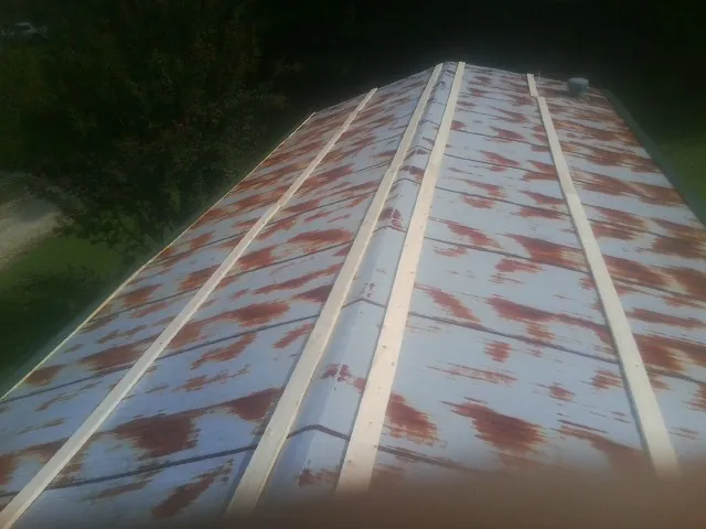 Rusted metal roof panels with new wood purlins before replacement — Storm Damage Roof Repair in East Bend by Roofing Brothers