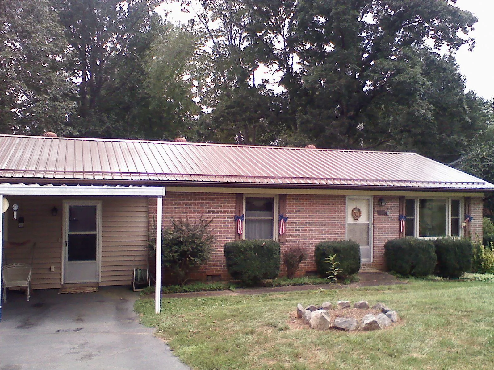 Bronze metal roof and carport on a brick ranch home — Roof Repair work by our crew in East Bend